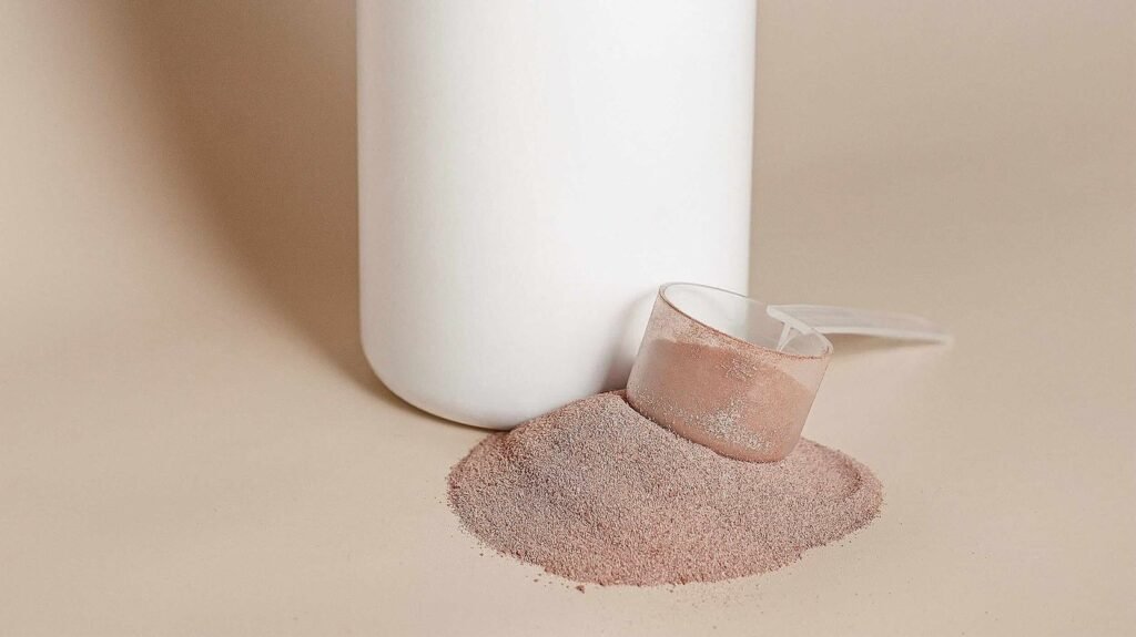 Inositol para el acné: ¿realmente vale la pena incorporarlo a tu rutina? Cuchara con myo-inositol en polvo y el polvo esparcido junto al envase, suplemento usado para el acné hormonal